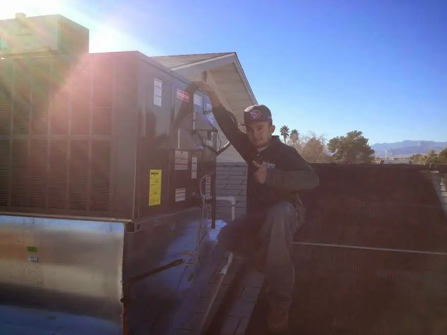 HVAC technician performing Air Duct Cleaning on a rooftop unit in Fergus Falls